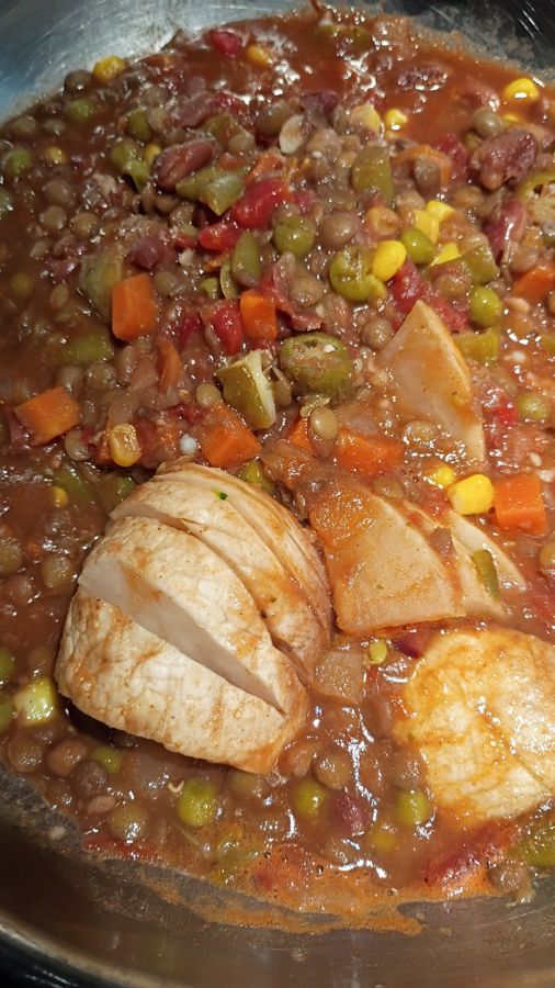 A pan of lentil stew with peas, corn, carrots, okra and tomato