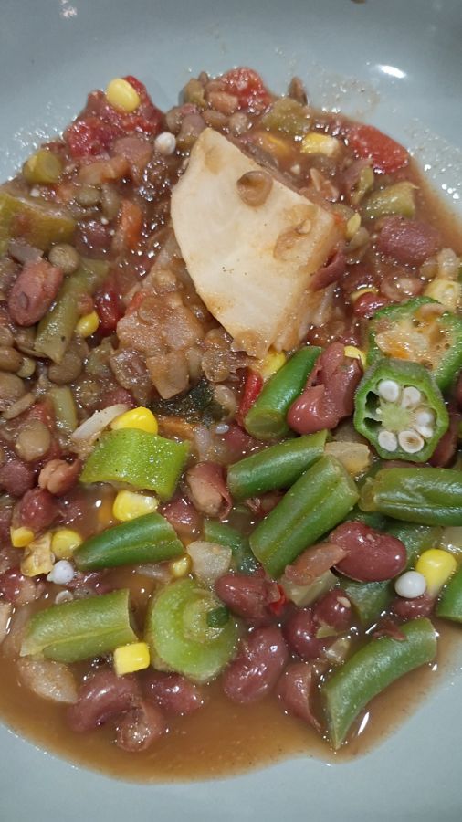 A plated bowl of the okra, bean and corn stew over lentils